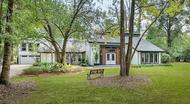 view of front of home featuring french doors, a front lawn, and a garage