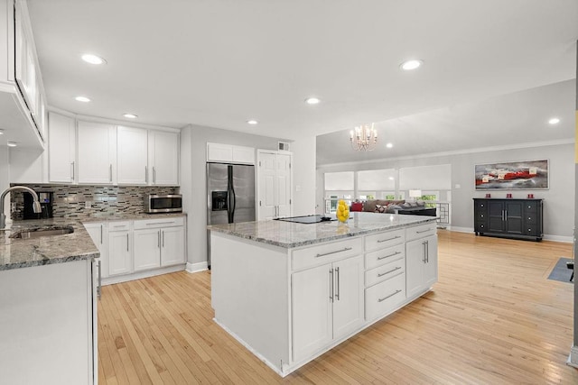 kitchen with white cabinetry, a kitchen island, stainless steel appliances, light hardwood / wood-style floors, and sink