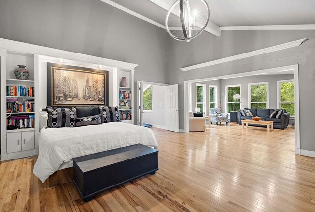 bedroom with high vaulted ceiling, multiple windows, light wood-type flooring, and a notable chandelier