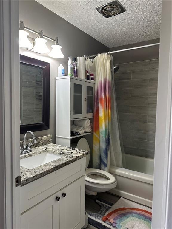 full bathroom with shower / bath combo with shower curtain, vanity, a textured ceiling, and toilet