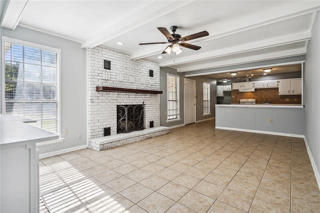 unfurnished living room featuring beam ceiling, ceiling fan, a fireplace, and light tile patterned floors