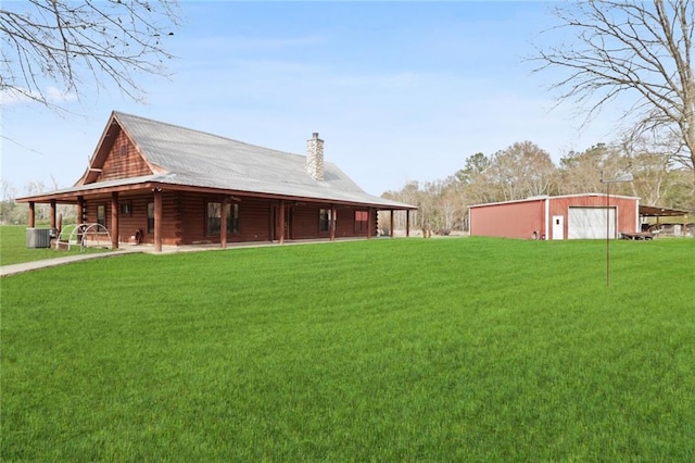 view of yard featuring a garage, an outbuilding, and central AC unit