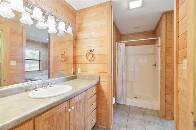 bathroom featuring wood walls, tile patterned floors, a shower with curtain, and vanity