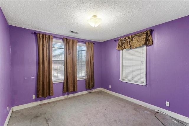 empty room with light carpet and a textured ceiling