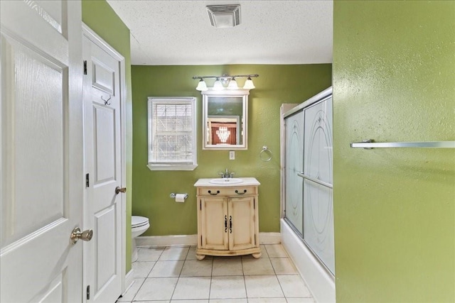 bathroom featuring a textured ceiling, tile flooring, toilet, and vanity