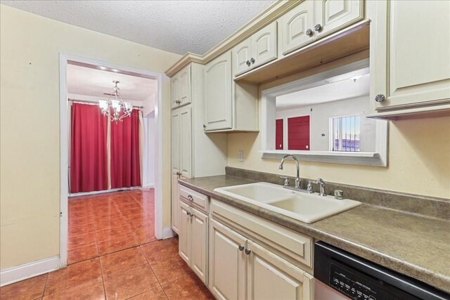 kitchen featuring a chandelier, light tile flooring, a textured ceiling, dishwashing machine, and sink