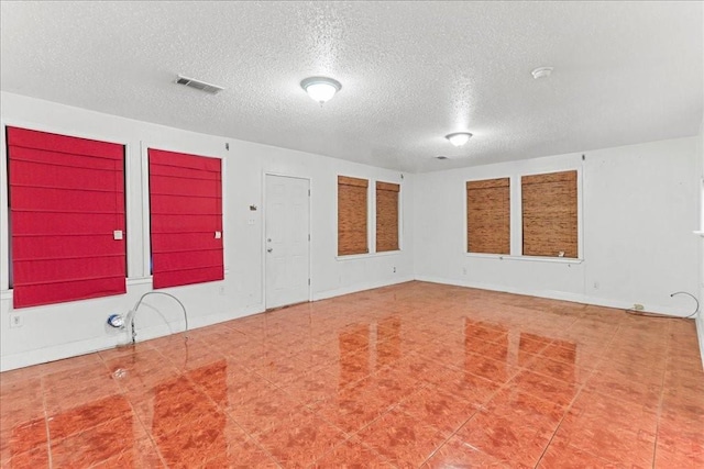 empty room featuring tile floors and a textured ceiling