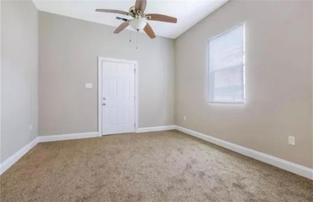 unfurnished room with light colored carpet and ceiling fan