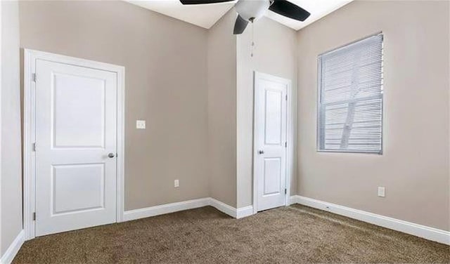 unfurnished bedroom featuring ceiling fan and dark carpet