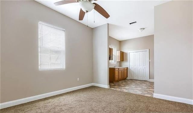 unfurnished bedroom featuring a closet, light carpet, and ceiling fan