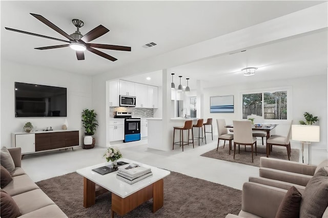 carpeted living room with ceiling fan and sink