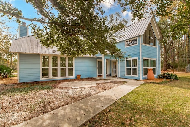 back of house featuring a lawn and a patio