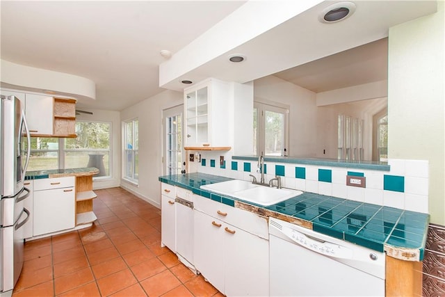 kitchen featuring sink, dishwasher, tasteful backsplash, and white cabinets