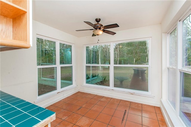 unfurnished sunroom with ceiling fan