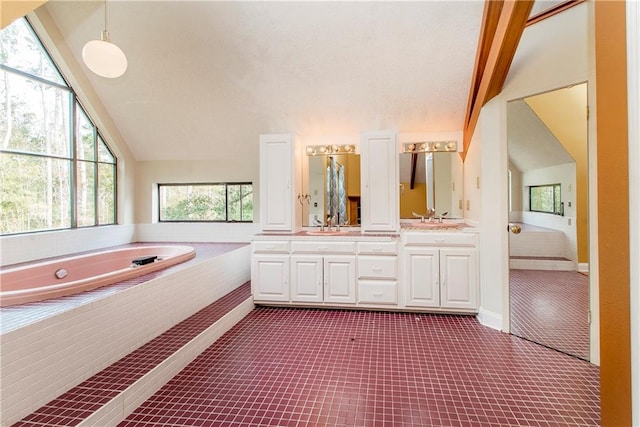 bathroom featuring dual sinks, a relaxing tiled bath, large vanity, and vaulted ceiling