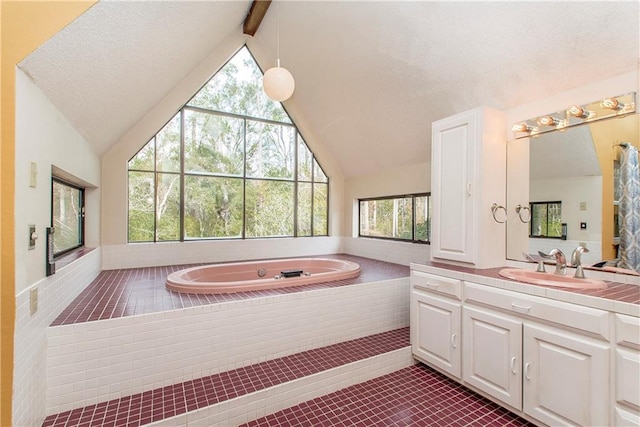 bathroom with tiled bath, tile floors, a textured ceiling, vanity, and vaulted ceiling with beams