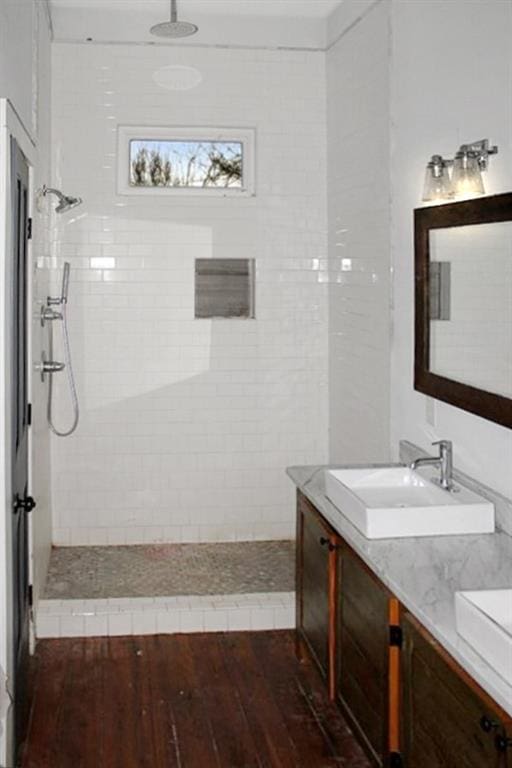 bathroom featuring tile walls, hardwood / wood-style floors, and a tile shower