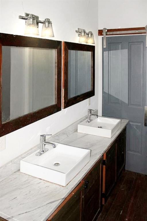 bathroom with double sink vanity and wood-type flooring