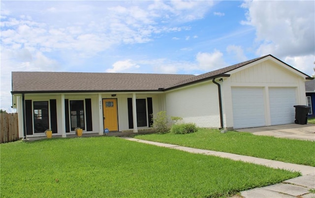 ranch-style house featuring a porch, a garage, and a front lawn