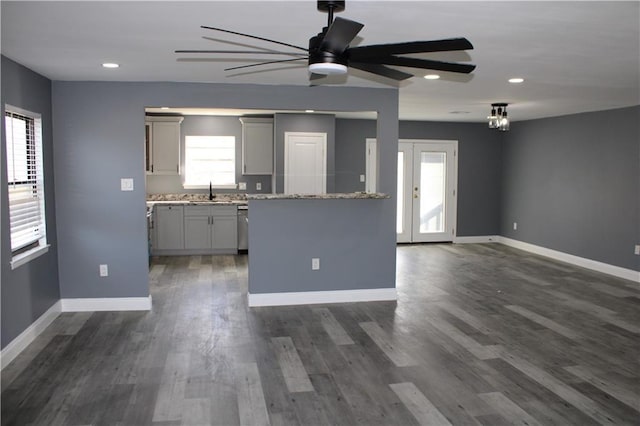 kitchen featuring plenty of natural light, ceiling fan, gray cabinetry, and light stone counters