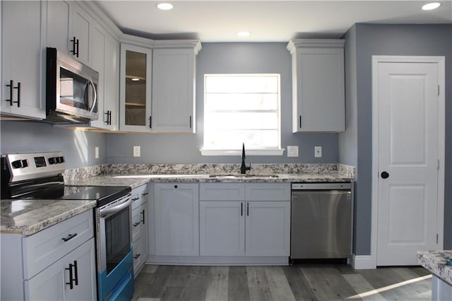 kitchen featuring light stone counters, sink, white cabinets, and stainless steel appliances