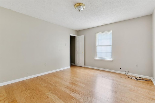 spare room featuring a textured ceiling and light wood-type flooring