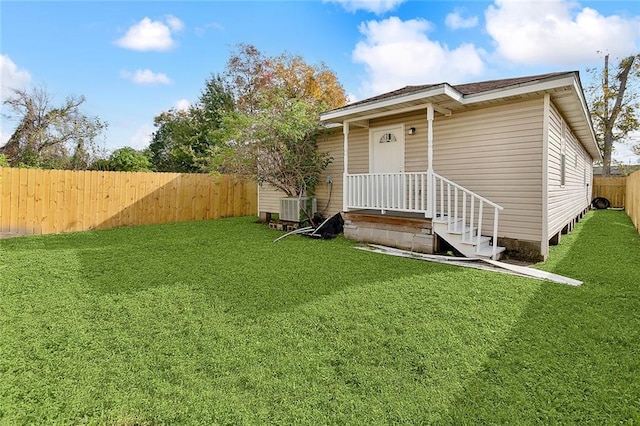 back of property with cooling unit and a lawn