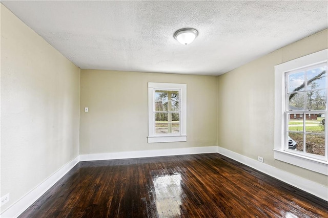 unfurnished room with a textured ceiling and dark hardwood / wood-style flooring