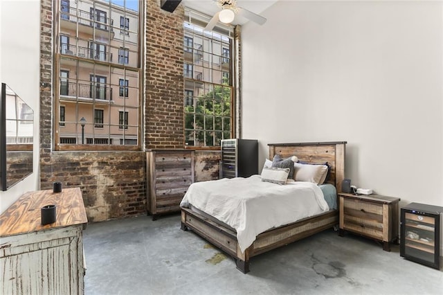 bedroom featuring ceiling fan, a high ceiling, and multiple windows