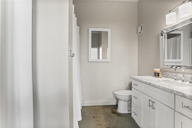 bathroom with concrete floors, oversized vanity, and toilet