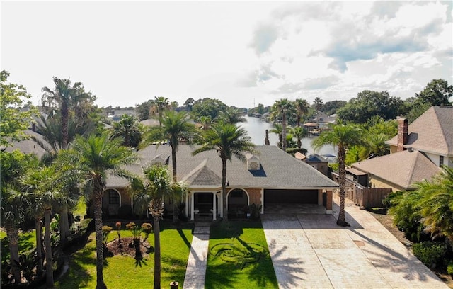 view of front of house with a water view and a front lawn