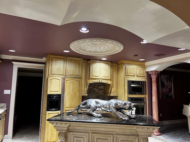 kitchen featuring light brown cabinetry, crown molding, stainless steel double oven, dark stone countertops, and a center island