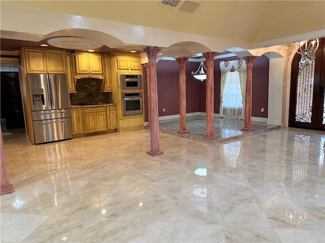 kitchen with arched walkways, marble finish floor, dark countertops, appliances with stainless steel finishes, and ornate columns