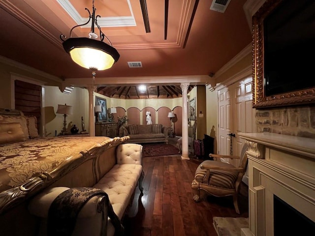 interior space featuring a raised ceiling, dark hardwood / wood-style floors, crown molding, and ornate columns