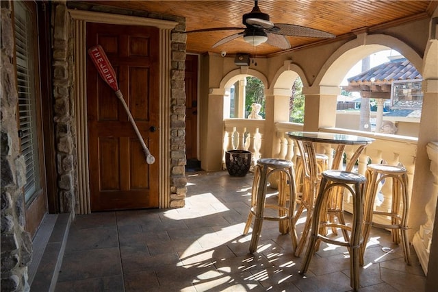 interior space featuring ceiling fan and a bar