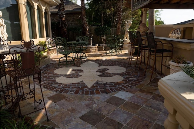 view of patio with exterior bar and fence