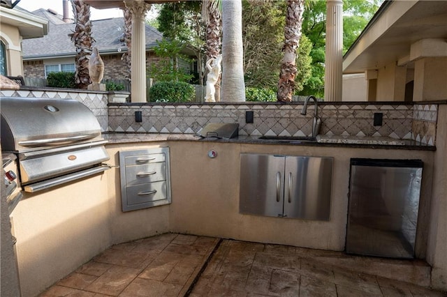 view of patio featuring exterior kitchen, grilling area, and a sink