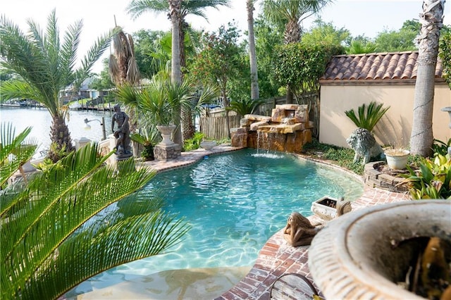 view of pool featuring a fenced in pool, a water view, and fence