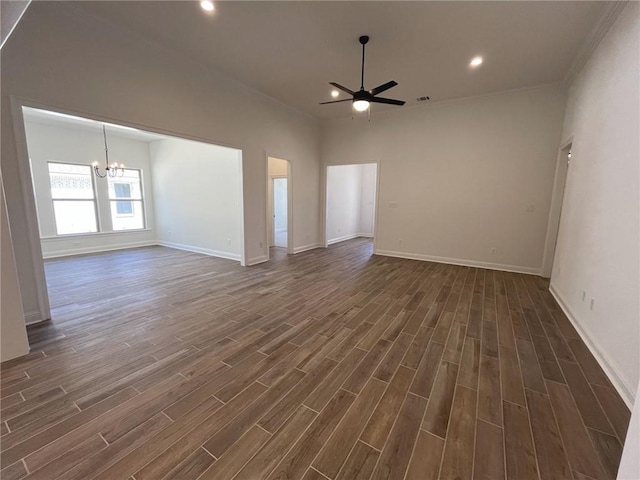 spare room with ceiling fan with notable chandelier, dark hardwood / wood-style floors, and crown molding