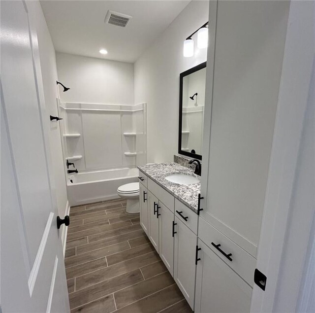 full bathroom featuring bathtub / shower combination, wood-type flooring, vanity, and toilet