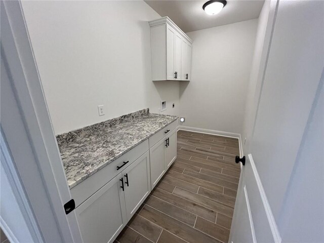 clothes washing area with cabinets, electric dryer hookup, dark hardwood / wood-style floors, and hookup for a washing machine