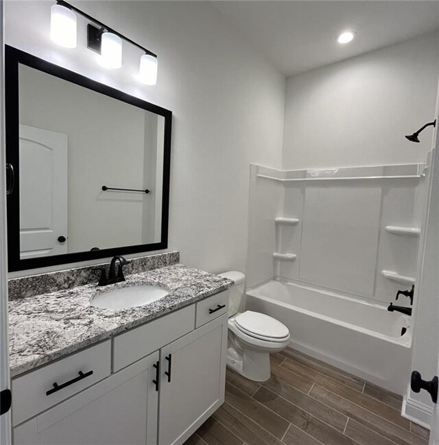 full bathroom with hardwood / wood-style floors, vanity, bathtub / shower combination, and toilet