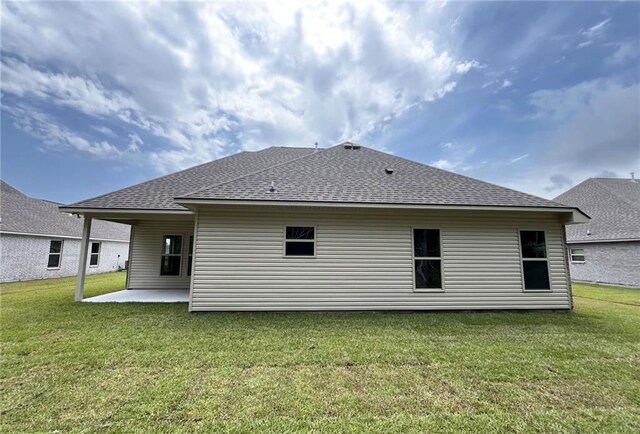 back of property with a yard and a patio area