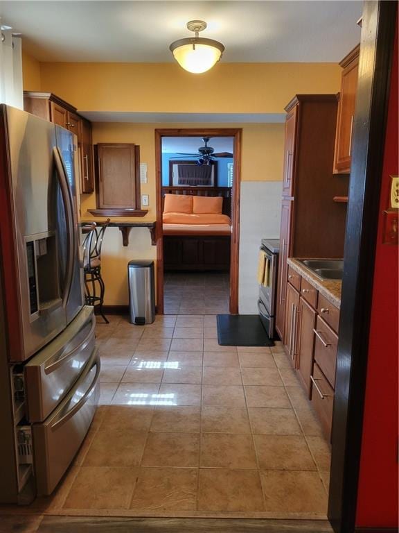 kitchen with ceiling fan, light tile flooring, and stainless steel appliances