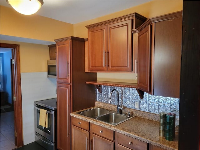 kitchen with sink, backsplash, tile floors, and stainless steel appliances