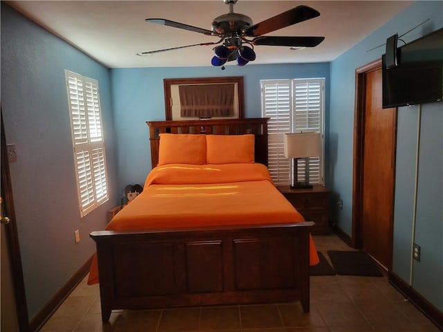 bedroom with dark tile floors and ceiling fan