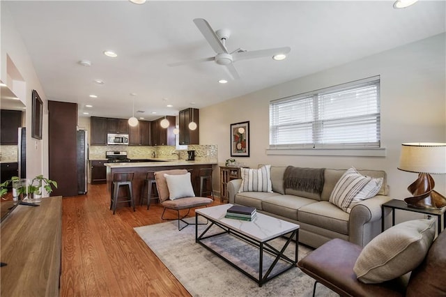 living room with ceiling fan and light hardwood / wood-style floors