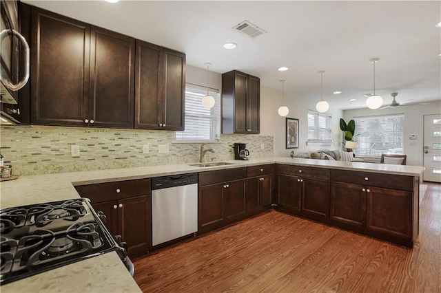 kitchen featuring hardwood / wood-style flooring, a healthy amount of sunlight, stainless steel appliances, and kitchen peninsula