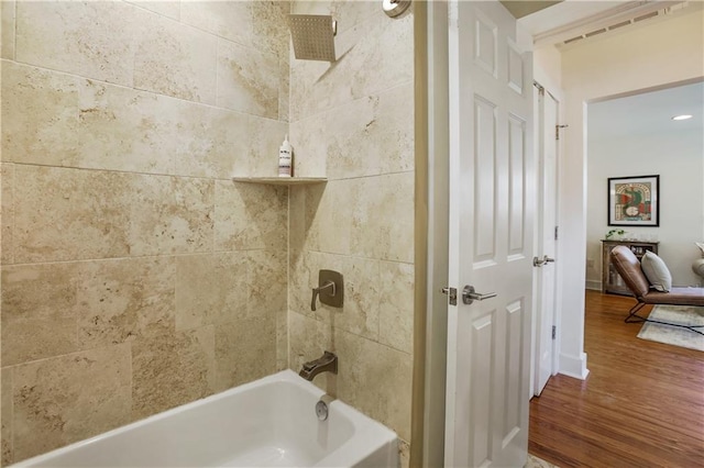 bathroom with tiled shower / bath combo and hardwood / wood-style flooring