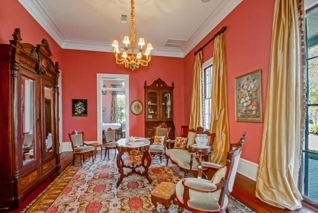 living area featuring a healthy amount of sunlight, wood-type flooring, and ornamental molding